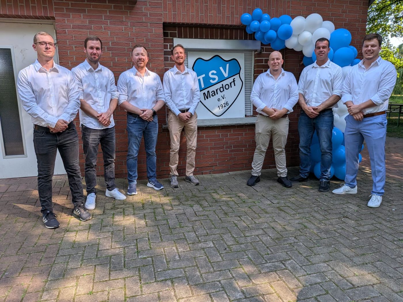 Der Vorstand vor dem TSV-Wappen